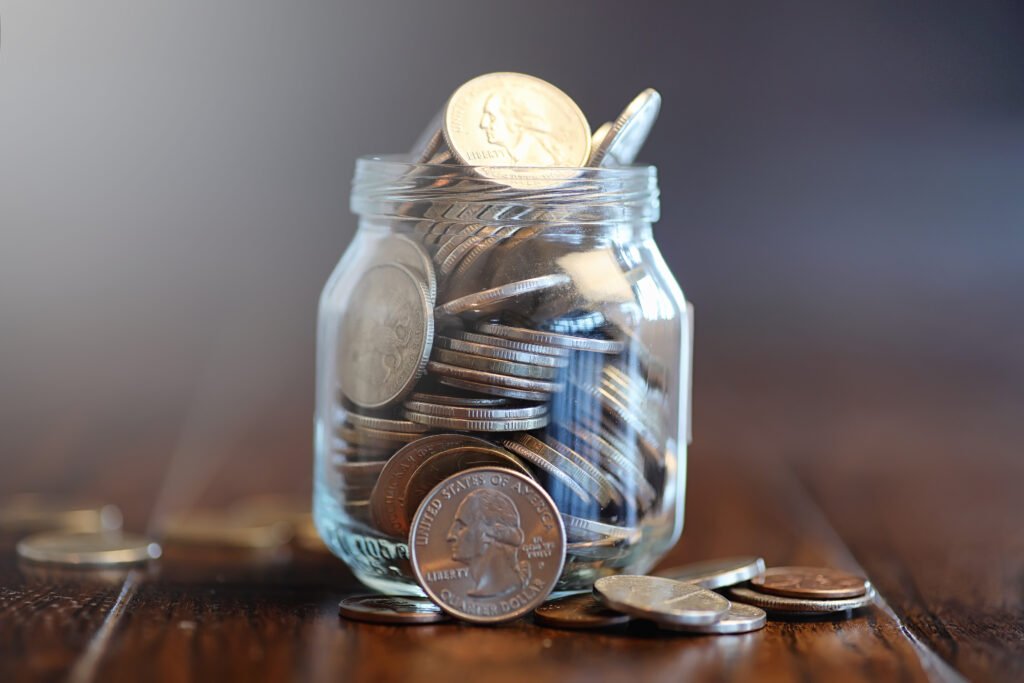 fondo de indemnizaciones: frasco de vidrio con monedas de ahorro