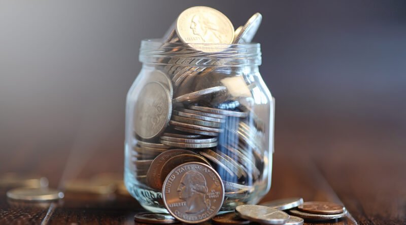 fondo de indemnizaciones: frasco de vidrio con monedas de ahorro