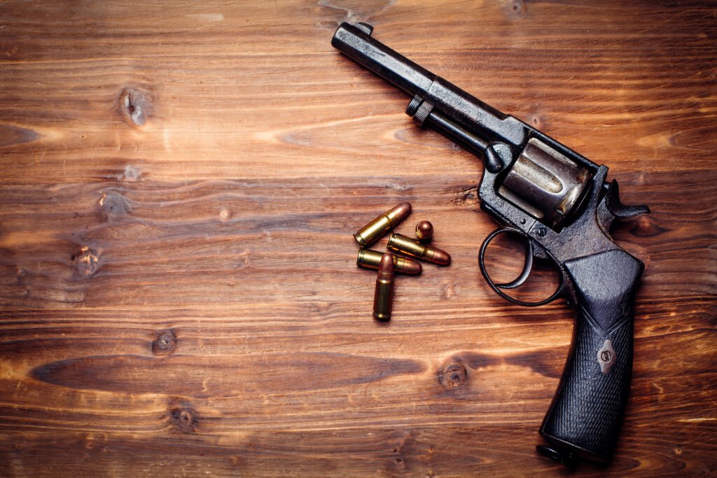 Pepita la Pistolera: pistolas antiguas sobre fondo de madera, estética noir