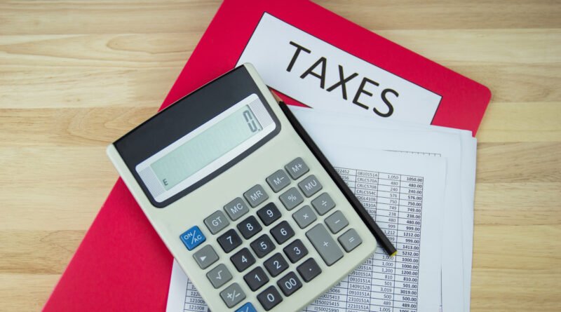 Recaudación de agosto: calculadora y documentos impositivos sobre un escritorio