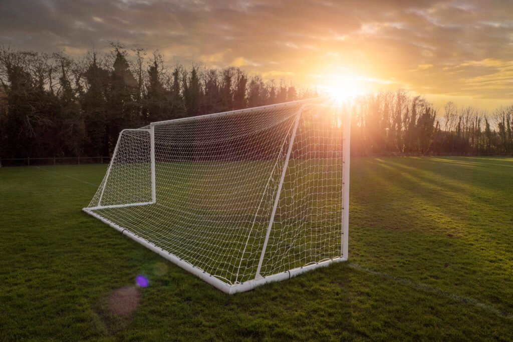 superclásico de Reserva: arco de fútbol en un campo de entrenamiento al atardecer