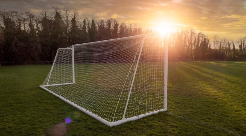 superclásico de Reserva: arco de fútbol en un campo de entrenamiento al atardecer