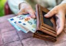 aumento de jubilaciones: jubilada sostiene una billetera con dinero