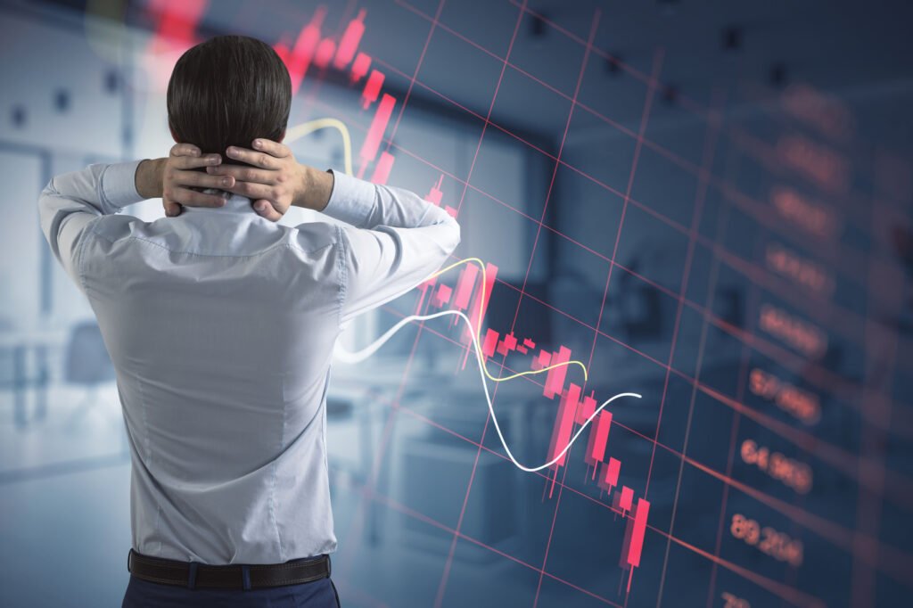 operador financiero frente a gráficos en rojo, cierre de mercados