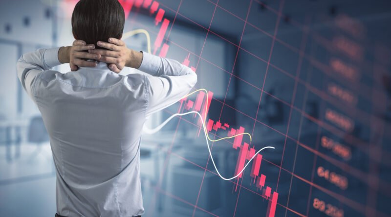 operador financiero frente a gráficos en rojo, cierre de mercados