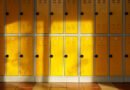 denunciar a alumnos: pasillo de escuela secundaria vacío con casilleros al sol