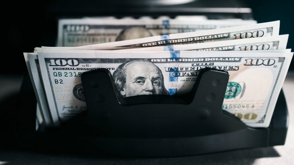 Dólar hoy: billetes de cien dólares en una máquina contadora