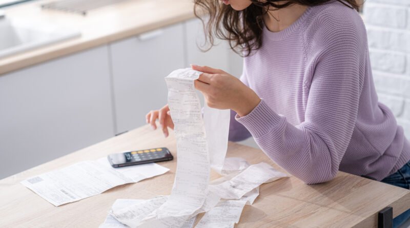 endeudamiento de las familias: mujer con facturas y calculadora en casa