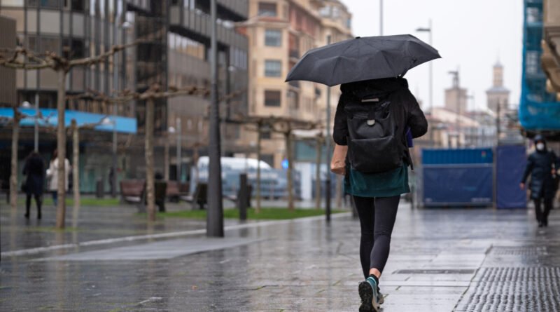 frío en el AMBA: persona con paraguas bajo la lluvia en la ciudad