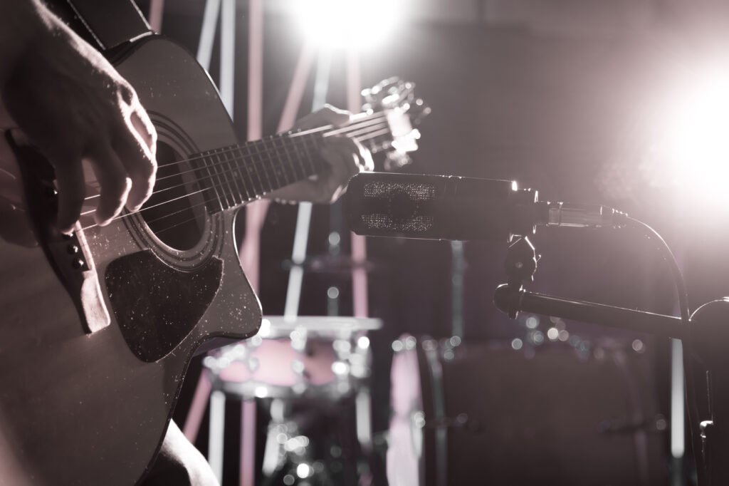hija de Piero: micrófono de estudio frente a una guitarra acústica
