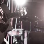 hija de Piero: micrófono de estudio frente a una guitarra acústica