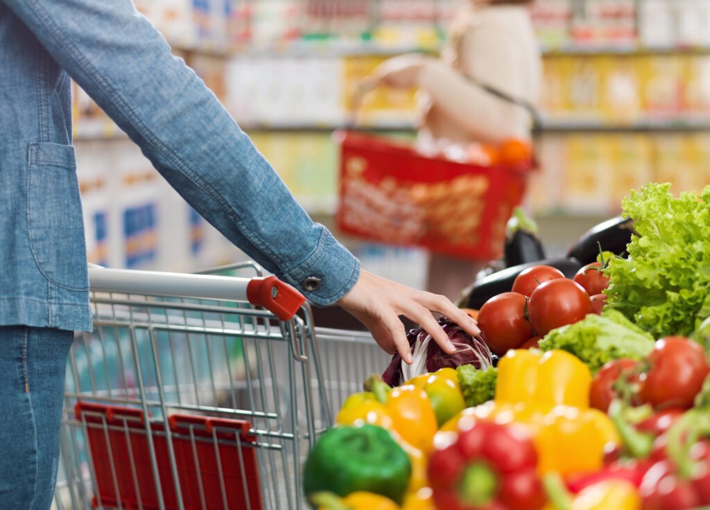 mujer con carrito de compras y verduras, inflación de septiembre