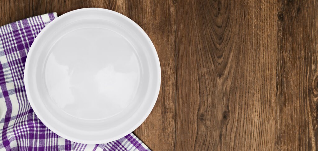 plato vacío sobre una mesa de madera, inseguridad alimentaria