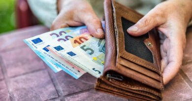 jubilaciones de ANSES: manos de una jubilada con billetes y billetera