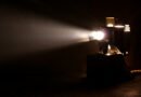La Masacre de Flores: proyector de cine antiguo con un haz de luz, clima dramático