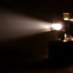 La Masacre de Flores: proyector de cine antiguo con un haz de luz, clima dramático