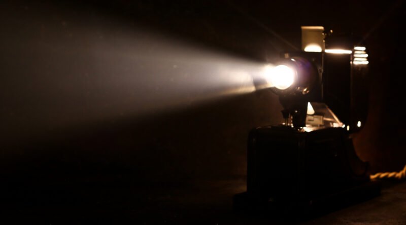 La Masacre de Flores: proyector de cine antiguo con un haz de luz, clima dramático