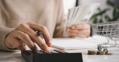 llegar a fin de mes: mujer cuenta gastos con una calculadora en su casa