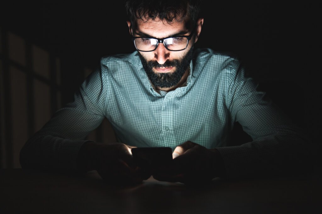 mano con un celular en una habitación oscura, Luck Ra