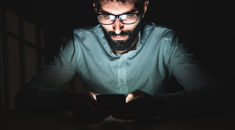 mano con un celular en una habitación oscura, Luck Ra