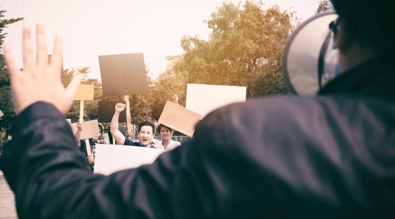 marcha universitaria: manifestantes con pancartas caminando por la calle
