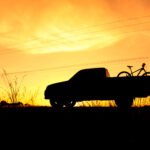 precios de pickups: camioneta pickup en un camino rural al atardecer