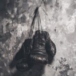 muerte del Roña Castro: guantes de boxeo sobre fondo oscuro
