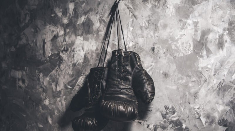 muerte del Roña Castro: guantes de boxeo sobre fondo oscuro
