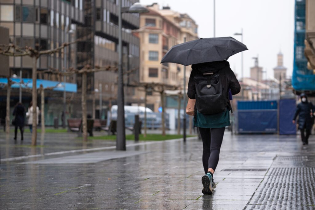 tormentas en Buenos Aires: persona con paraguas en una calle lluviosa