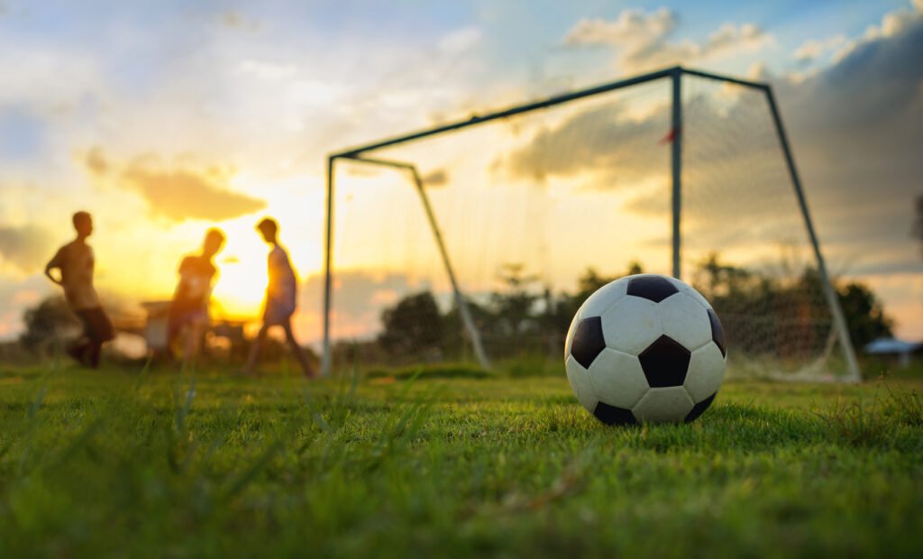 vuelta de la Promoción: partido de fútbol en una cancha al atardecer