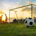 vuelta de la Promoción: partido de fútbol en una cancha al atardecer