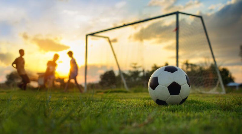 vuelta de la Promoción: partido de fútbol en una cancha al atardecer